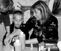 HANDPRINT QUILT: Ricky Hodgins, 5, has fun making his own handprint under the watchful eye of teacher Janice Taylor.